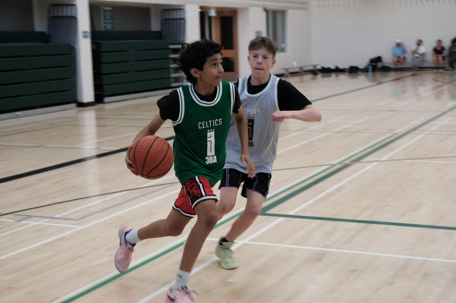 Two players in 3BA Celtics and Spurs jerseys battling for the ball in a 3x3 game